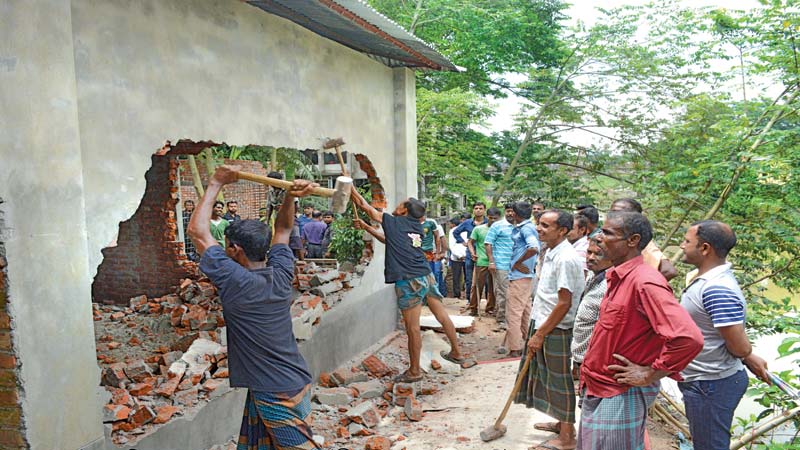 Illegal structures on river bank pulled down